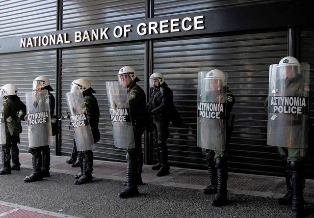 Griechische Polizisten schtzen Ende F...bank vor aufgebrachten Demonstranten.   | Foto: dpa
