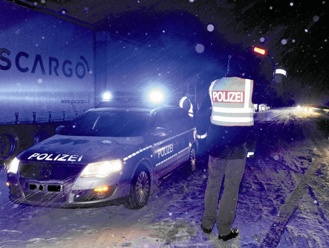 Im Schneetreiben gibt ein Polizist mit...engend Leute zur Verfgung standen.    | Foto: BZ