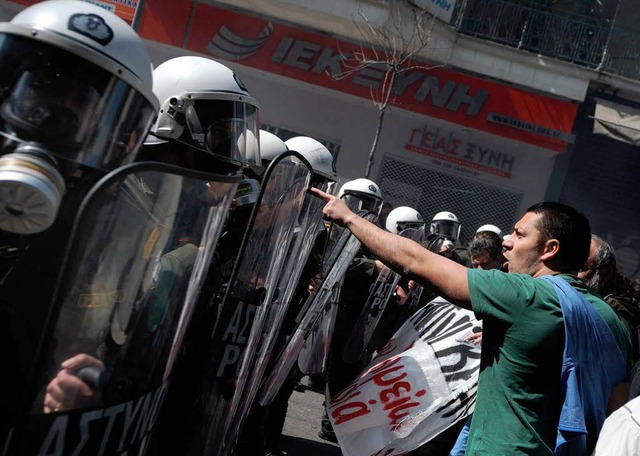 Demonstrant vor einer Wand aus Polizisten.  | Foto: dpa