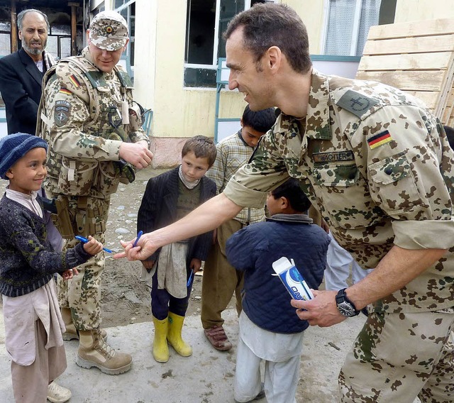 Hei begehrte Kugelschreiber: Deutsche Soldaten in Kundus beschenken Kinder.   | Foto: DPA