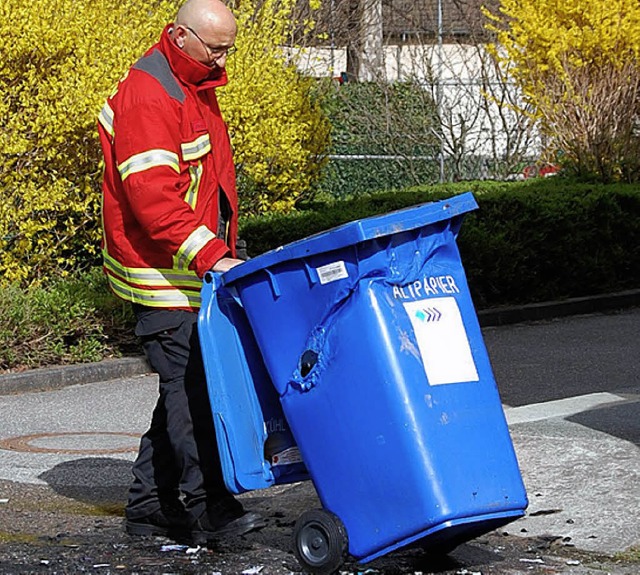 Feuerwehrmann Stefan Kirn begutachtet die durch die Hitze verformte Papiertonne   | Foto: Frey