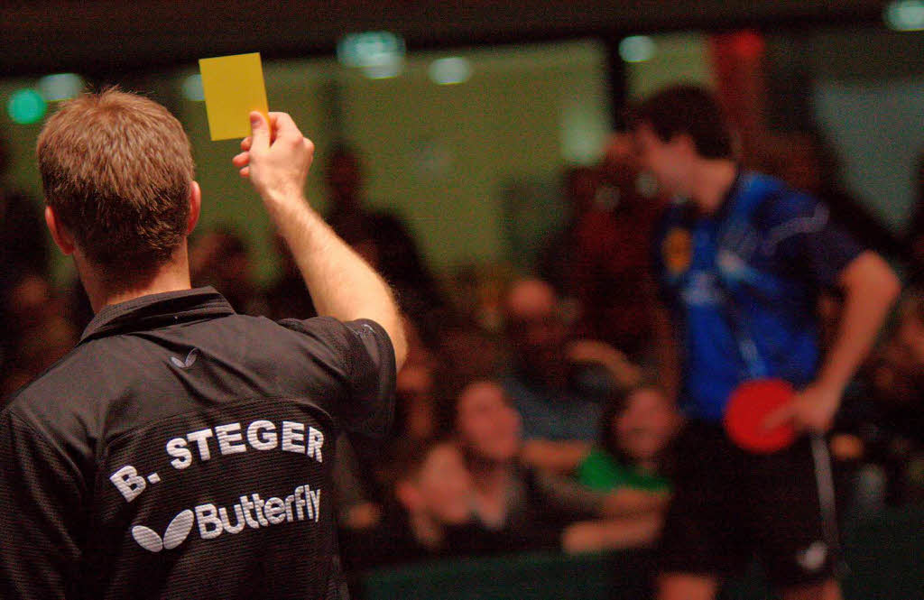 Timo Boll scherzt mit dem Publikum, Bastian Steger scherzt zurck und zeigt die gelbe Karte.
