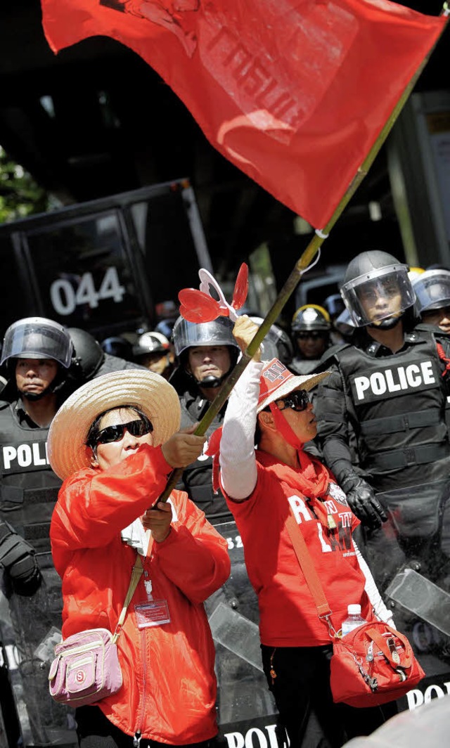 Die Roten Hemden demonstrieren, die Polizei schaut zu.  | Foto: dpa