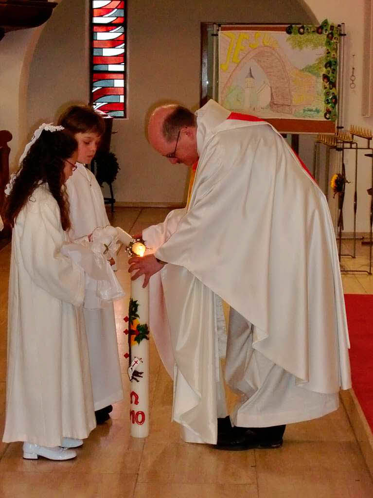 Pfarrer Johannes Buchmller zndet die Kerzen der Kommunionskinder aus Lenzkirch an.
