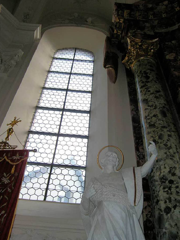 Die Seitenfenster mit klarem Glas neben dem Hochaltar und das Mehr an Licht im Chorraum werten die Heiligenfiguren und Altarsulen auf.