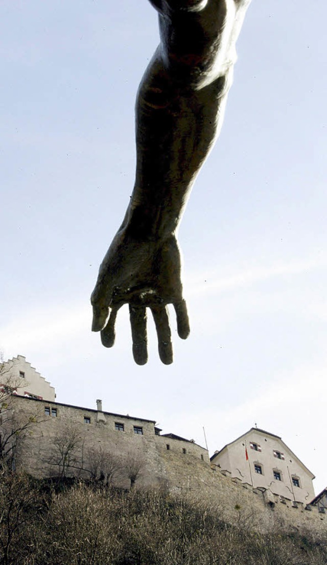 Die Hand einer Statue greift nach dem Schloss von Vaduz   | Foto: dpa