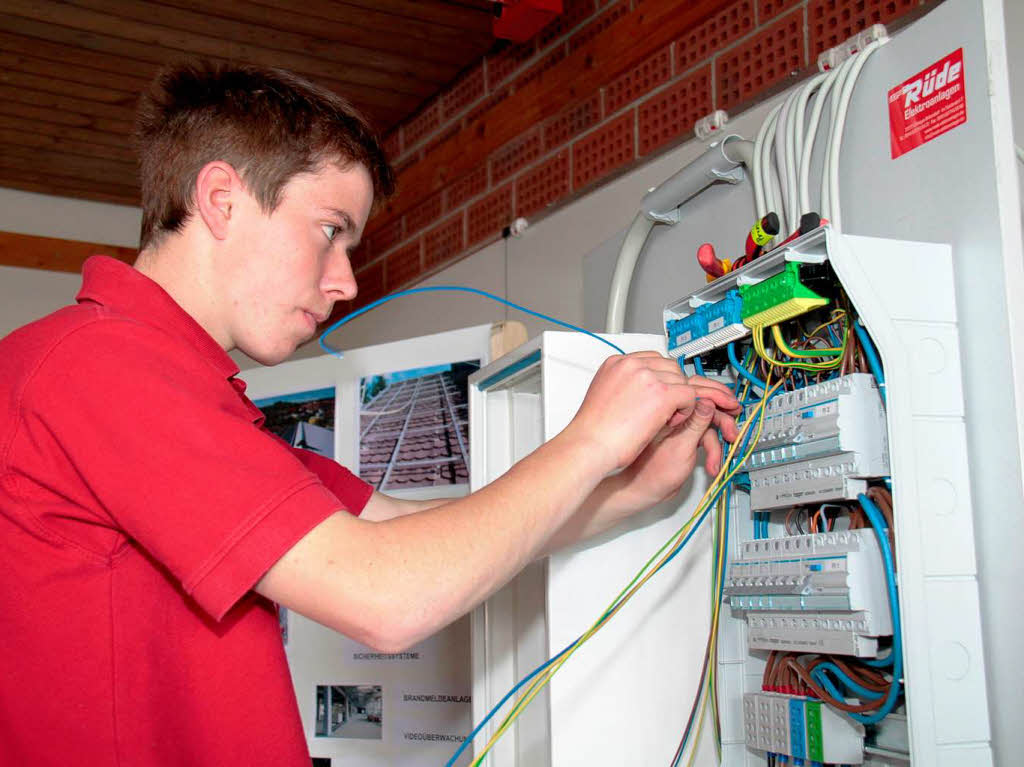 Dominik Lindt, Azubi im ersten Lehrjahr, zeigt am Infostand der Firma Elektro-Rde  Installationen an einem Schaltschrank.
