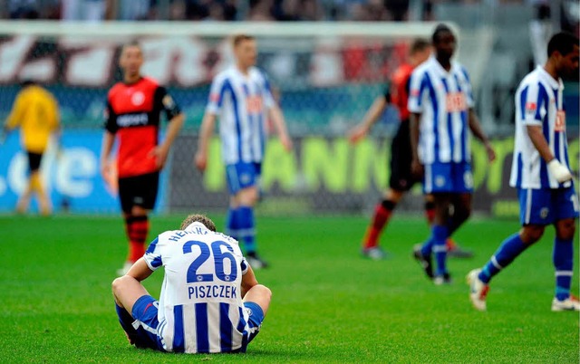 Herthas Lukasz Piszczek  sitzt nach dem Spiel mit gesenktem Haupt auf dem Platz.  | Foto: ddp