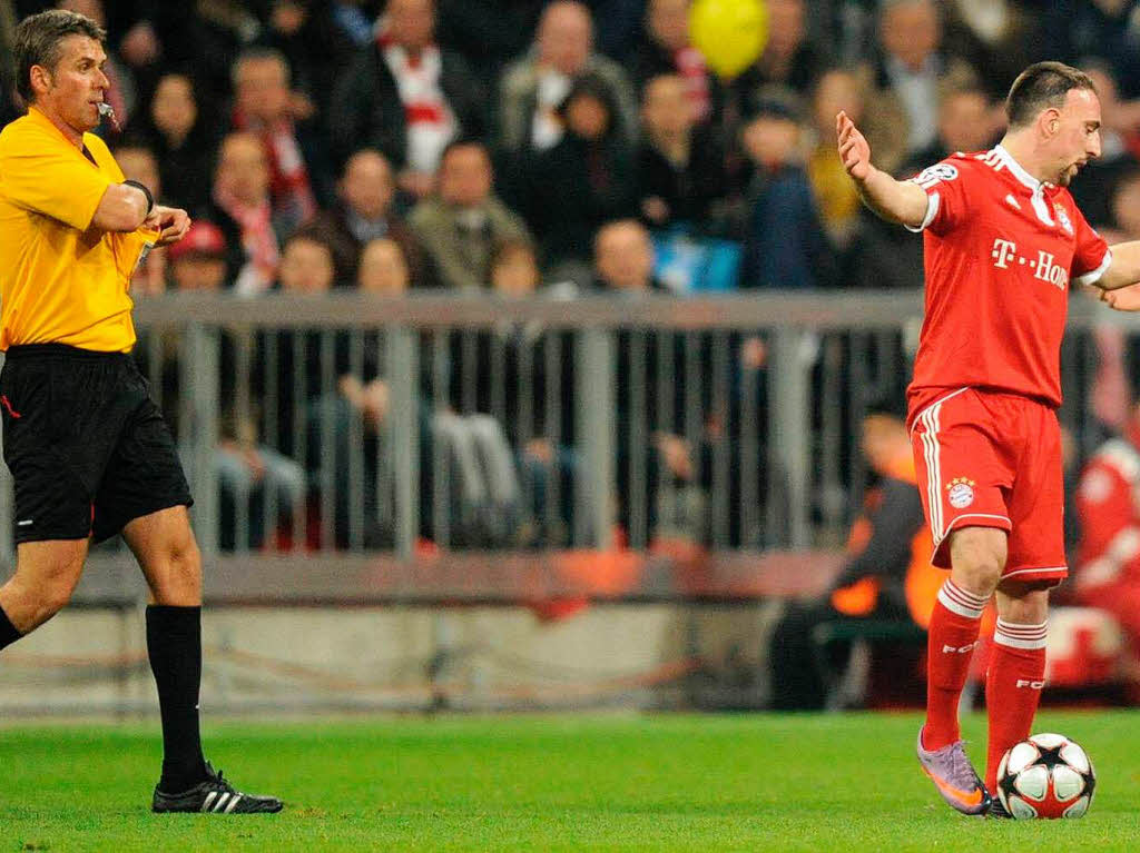 Muenchens Franck Ribery (Frankreich) gestikuliert kurz nach seinem Foul gegen Lyons Lisandro Lopez (Argentinien, nicht im Bild), waehrend Schiedsrichter Roberto Rosetti (l.) die rote Karte zckt.