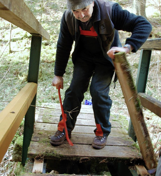 Damit sich niemand verletzt, tauscht E...auf einem Steg ein morsches Brett aus.  | Foto: Sebastian Barthmes