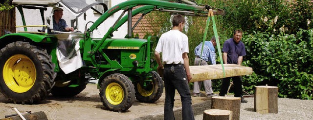 Nur mit Hilfe eines Traktors konnten die schweren Holztische aufgebaut werden.  | Foto: Katrin Hundorf