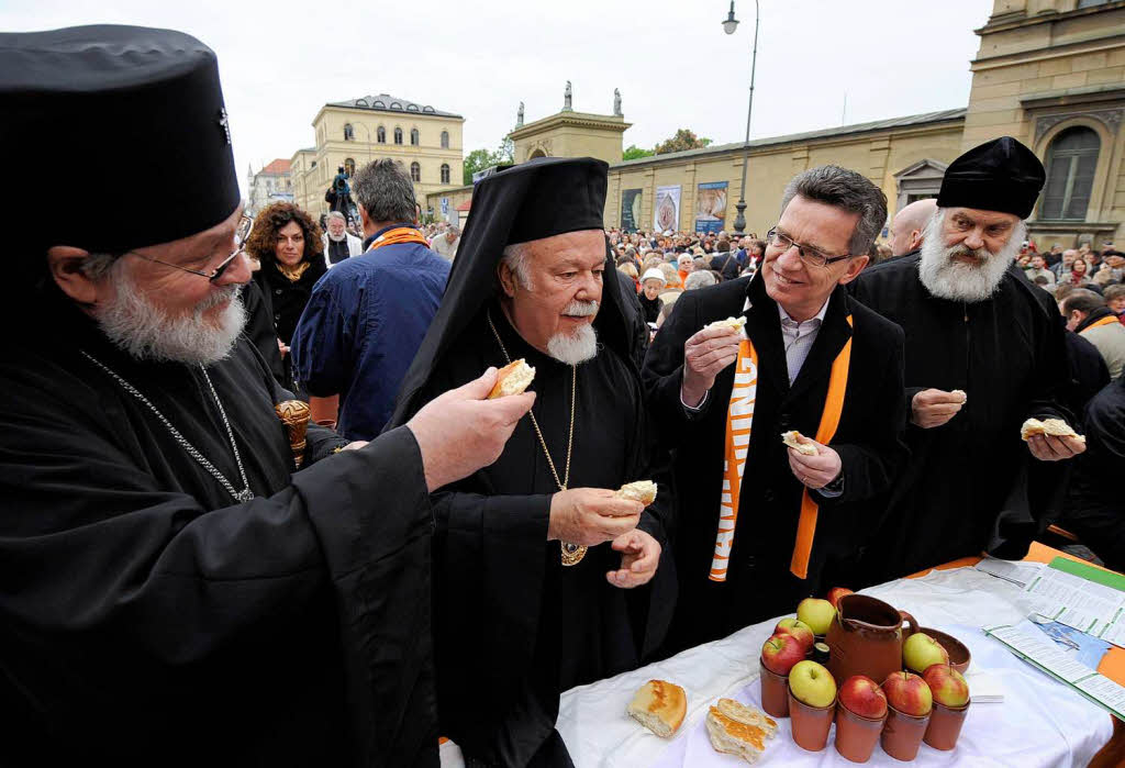 Der griechisch-orthodoxe Metropolit Augoustinos (2.v.l.) teilt  bei der orthodoxen Vesper  Brot mit Bundesinnenminister Thomas de Maiziere (CDU, 2.v.r.)