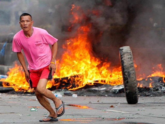 Mit brennenden Barrikaden (hier aus Re...lle in Bangkok die Armee auf Distanz.   | Foto: dpa