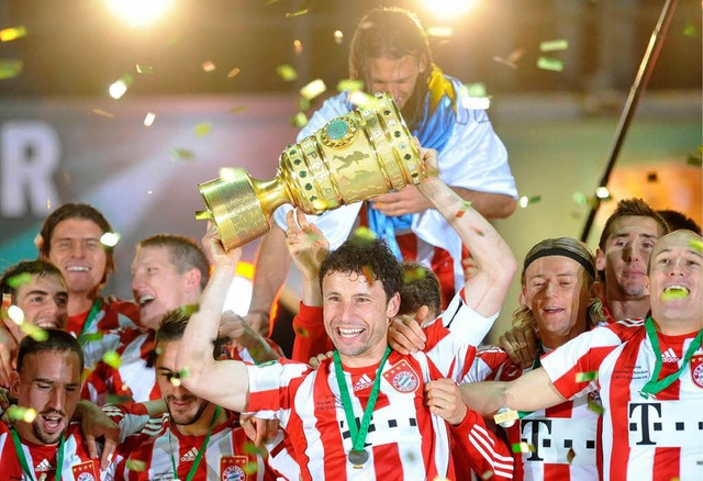 Stolz prsentiert Bayern-Kapitn Mark van Bommel den DFB-Pokal.   | Foto: ddp