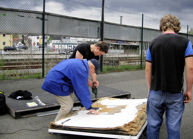 Jugendliche und Klemens Hirt Hand arbeiten an einem der kaputten Zielbretter.    | Foto: nadja dilger