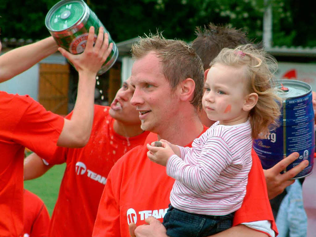 Spielertrainer Andreas Paschke mit Tochter Aliya, whrend im Hintergrund das Bier in Strmen fliet