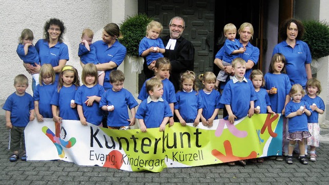 Kinder, Erzieherinnen und Pfarrer prsentieren den Namen des Kindergartens.   | Foto: Hans Spengler