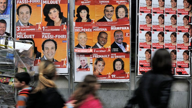 Passanten gehen in Brssel an Wahlplakaten vorbei.   | Foto: AFP