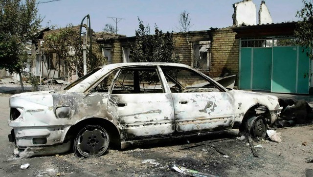 Ein ausgebranntes Auto zeugt von den Unruhen in Kirgistan.  | Foto: dpa