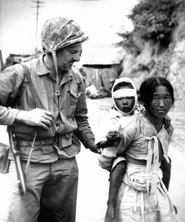 Im Krieg: Ein US-Soldat steckt einer Koreanerin  eine Essenskonserve  zu   | Foto: dpa