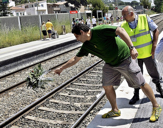 Ein Mann wirft einen Blumenstrau auf ... ein Zug in eine Menschenmenge raste.   | Foto: dpa