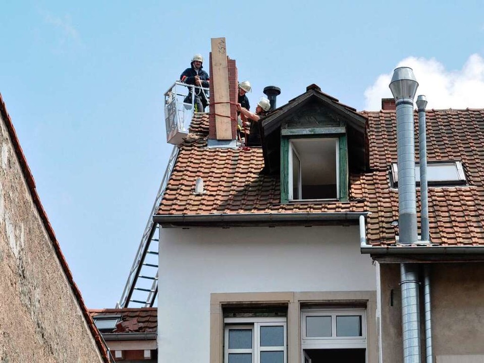 Feuerwehrleute sichern die Reste des blitzgeschädigten Schornsteins.   | Foto: Barbara Ruda