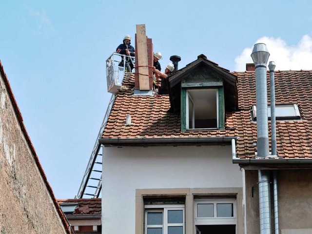 Feuerwehrleute sichern die Reste des blitzgeschdigten Schornsteins.   | Foto: Barbara Ruda