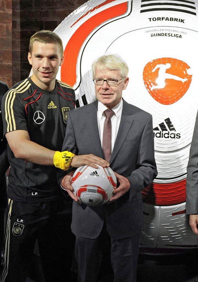 DFL-Chef Reinhard Rauball (rechts) zei...t Nationalspielern wie Lukas Podolski.  | Foto: afp