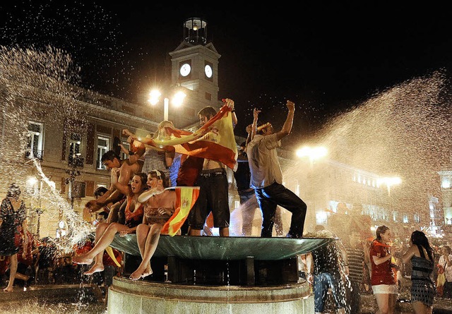 Spanien feiert: Badende Fans an einem ...en an der  Puerta del Sol  in Madrid.   | Foto: afp