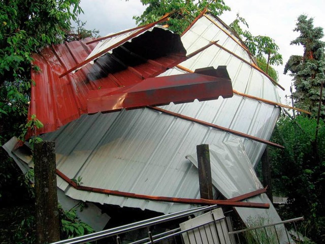 Teile eines Wellblechdachs der Halle e...irma in Schuttern  landeten im Garten.  | Foto: dpa