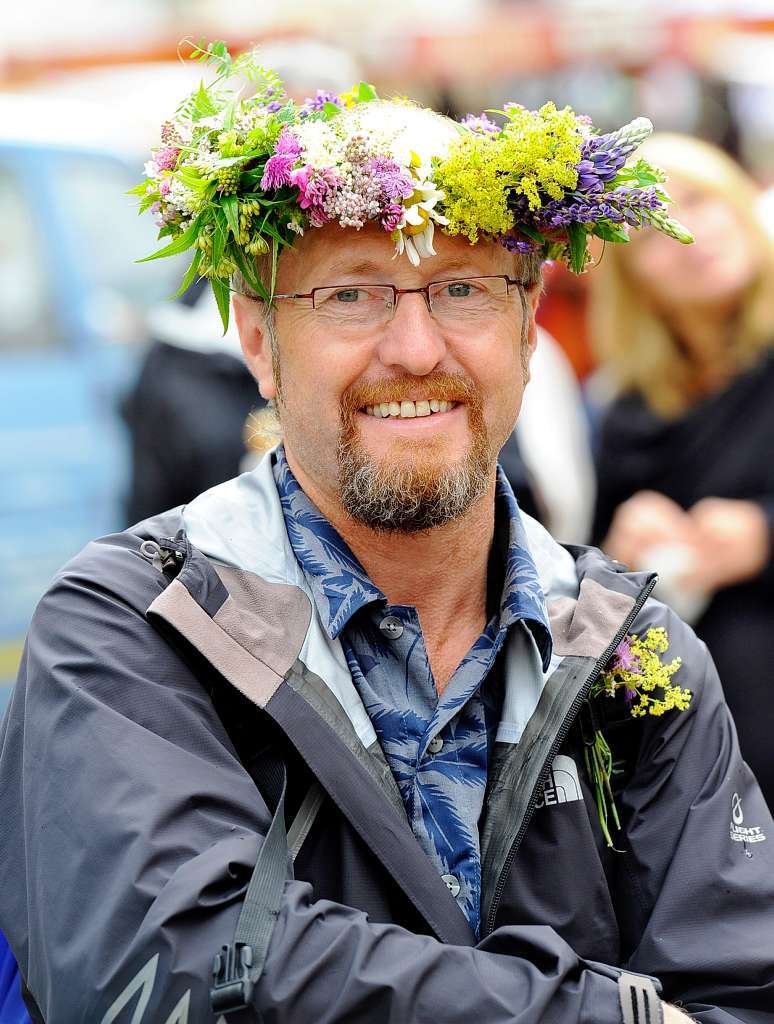 Die Gruppe hat Wanderfhrer Lutz Hhner zum krnenden Abschluss der Tour einen Blumenkranz gebunden.