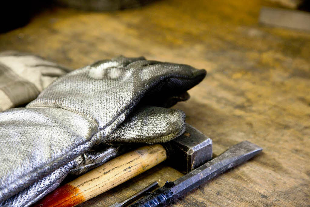 Zum Schutz trgt der Kremationstechniker bei seiner Arbeit feuerfeste Handschuhe.