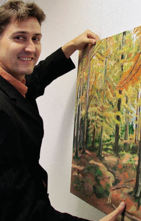Thomas Willmann richtet eines seiner Wald-Gemälde.  | Foto: nicole mai