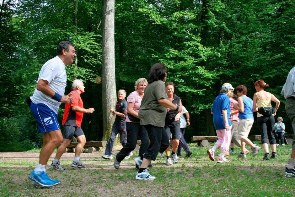Fitnesstraining mit Oscar Guidone: Die Teilnehmer joggen über den Platz und müssen sich dann spontan zu Gruppen zusammenfinden. (Foto: Friederike Marx)