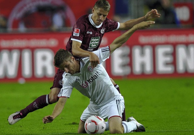 Der Lauterer Torschtze Ivo Ilicevic im Zweikampf mit Thomas Mller (vorn)    | Foto: AFP