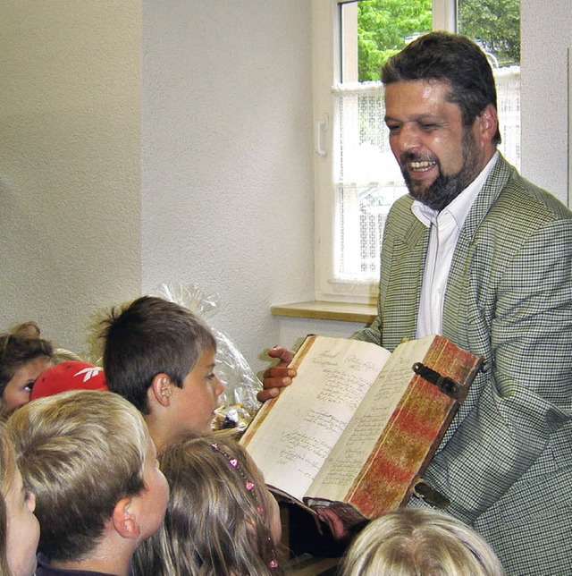 Mit Interesse warfen die Kinder einen Blick in das alte Grundbuch der Stadt.  | Foto: Marinanne Rittner