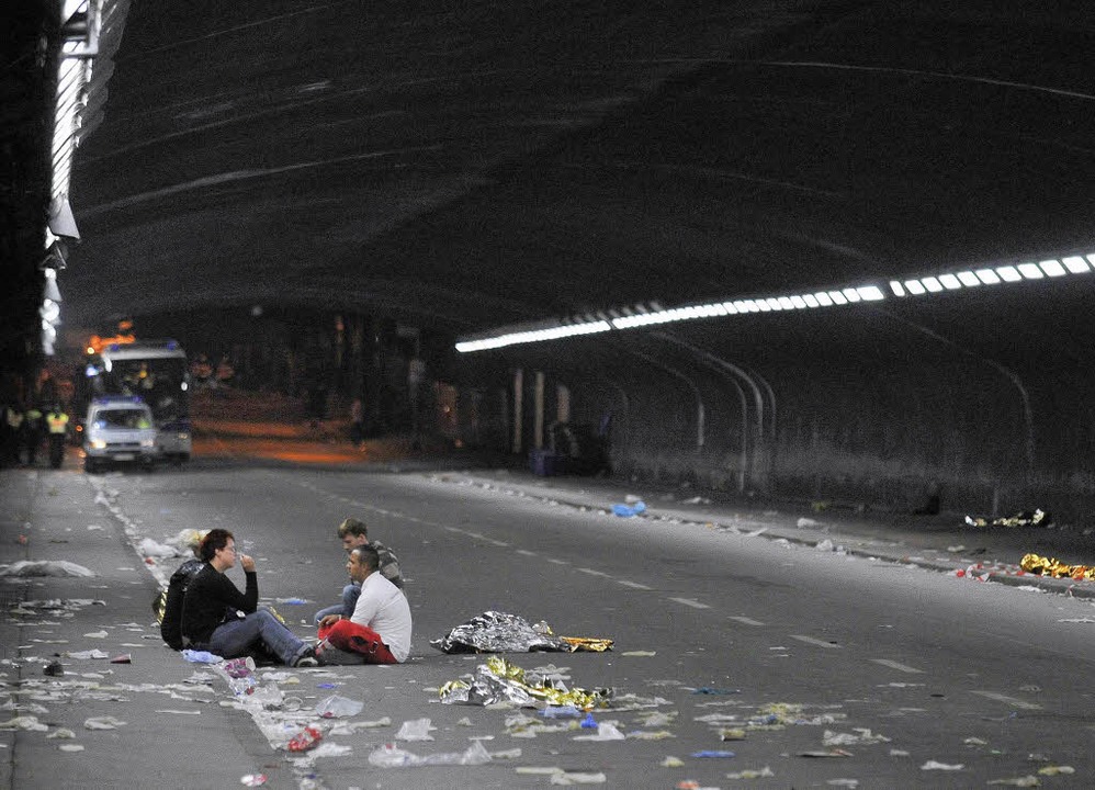 Besucher der Loveparade sitzen am Tag der Katastrophe in dem Tunnel in Duisburg.  | Foto: ddp