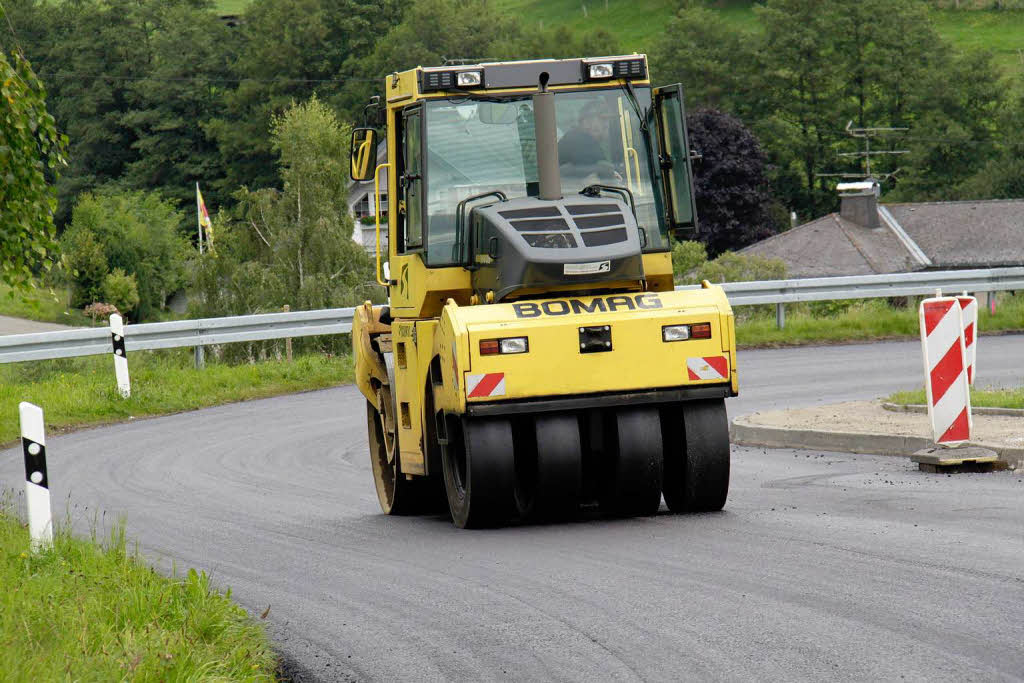 Die erste Bitumenschicht wurde auf der L157 in der Ortsmitte von Grafenhausen aufgebracht und kräftig gewalzt Die erste Bitumenschicht wurde auf der L157 in der Ortsmitte von Grafenhausen aufgebracht und kräftig gewalzt