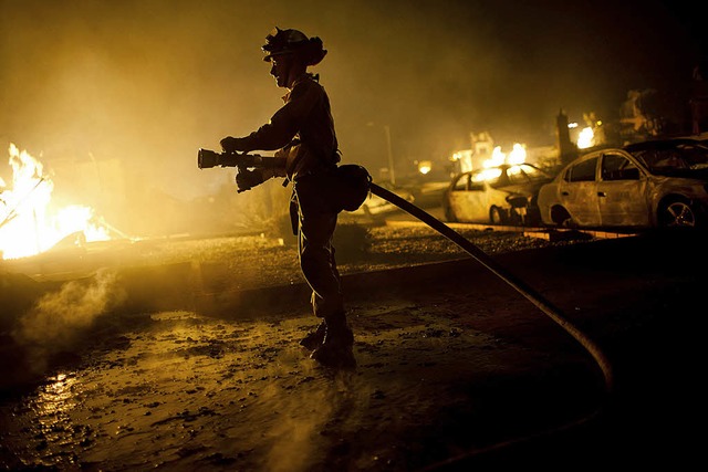 Flammen und Zerstrung: ein Feuerwehrmann in San Bruno  | Foto: afp