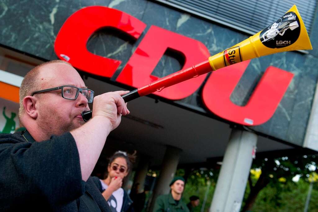 Mit einer Vuvuzela protestiert ein Gegner von Stuttgart 21 am Freitagabend in Stuttgart vor einem CDU-Gebude.