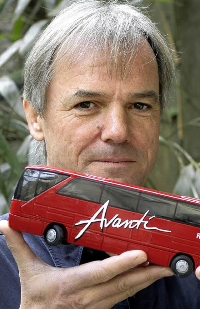 Hans-Peter Christoph mit einer Mini-Ausgabe eines seiner knallroten Reisebusse  | Foto: bz