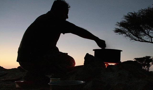 Unter dem kritischen Auge des Wstenfuchses: Ein Men zubereiten in der Sahara   | Foto: DDP