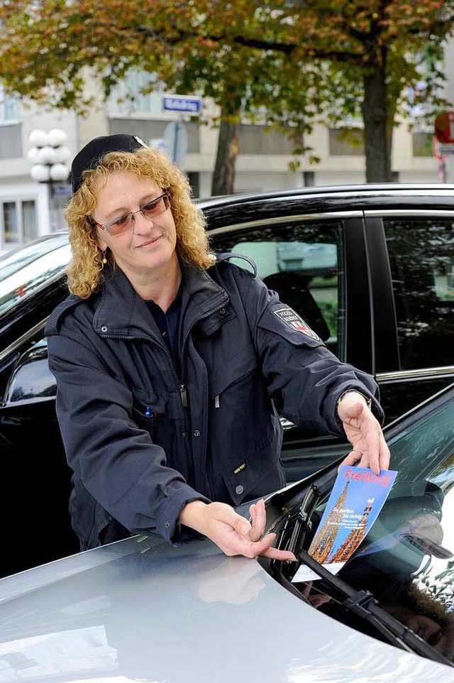 Sieglinde Arny vom GVD  klemmt den Flyer unter den Scheibenwischer eines Autos.  | Foto: Schneider