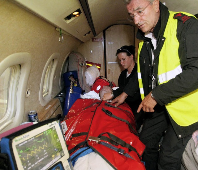 Flugarzt Reiner Wagner (rechts) betreut den Patienten.   | Foto: dpa