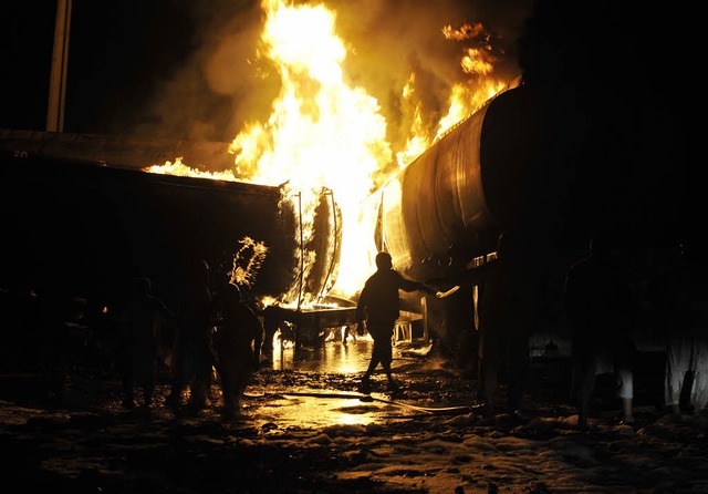 Feuerwehrleute versuchen, die  brennenden Tanklastwagen zu lschen.    | Foto: afp