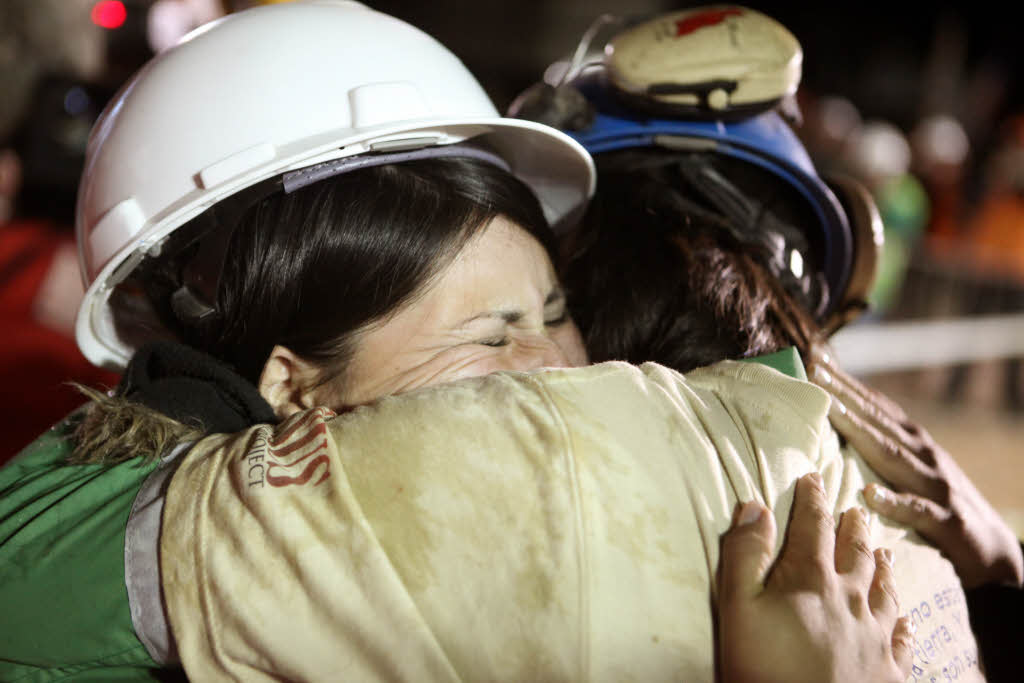 Der Bergarbeiter Osman Araya und seine Frau umarmen einander.