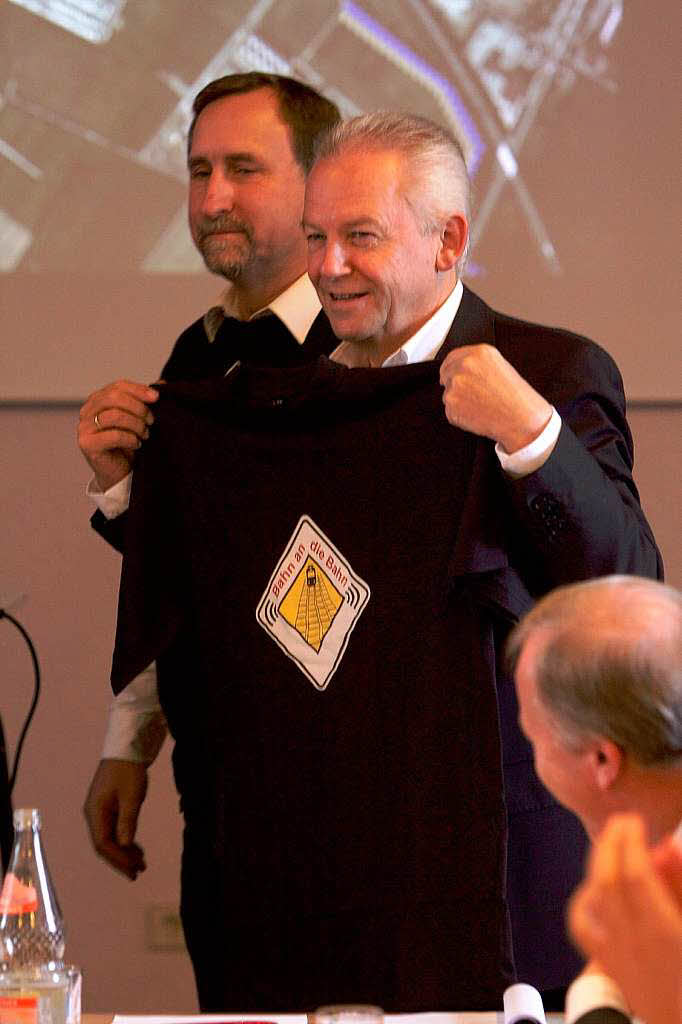 Geschenk fr Grube: Der  Bahn-Chef posiert mit einem T-Shirt der BI "Bahn an die Bahn"