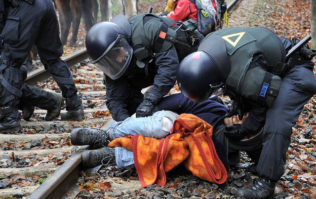 Polizisten berwltigen einen Gleisbes...gen den Castor-Transport protestiert.   | Foto: DPA