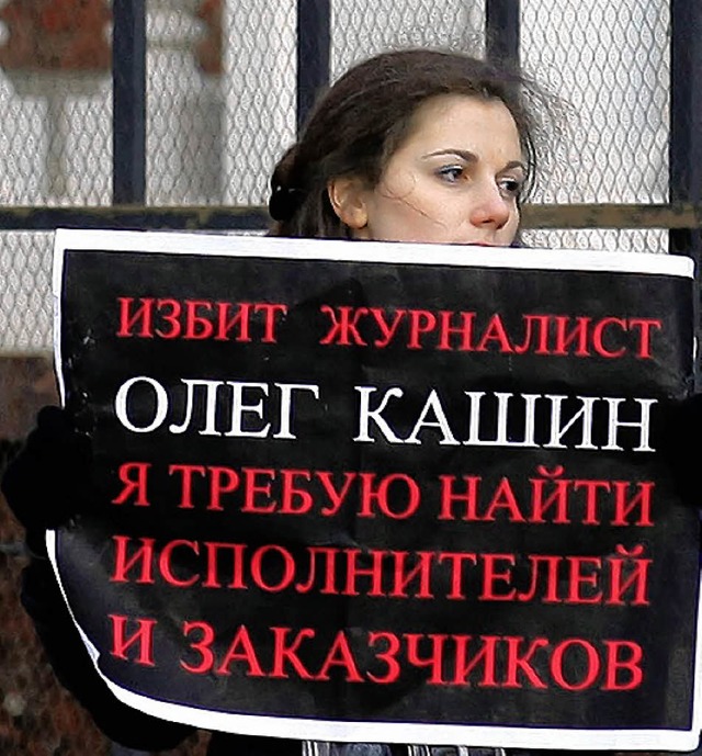 Eine Frau mit einem Protestplakat erinnert an Oleg Kaschin.  | Foto: afp