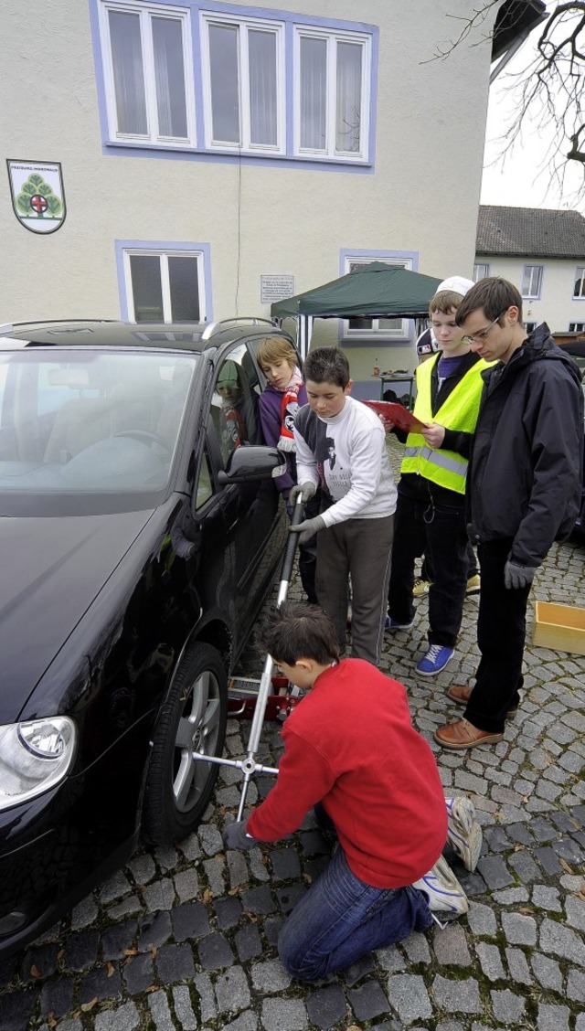 Tobias (kniend) lockert die Schrauben,...lke (von links) schauen zu und helfen.  | Foto: Kunz